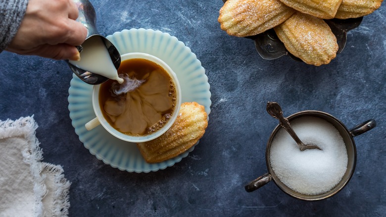 Pouring creamer into coffee