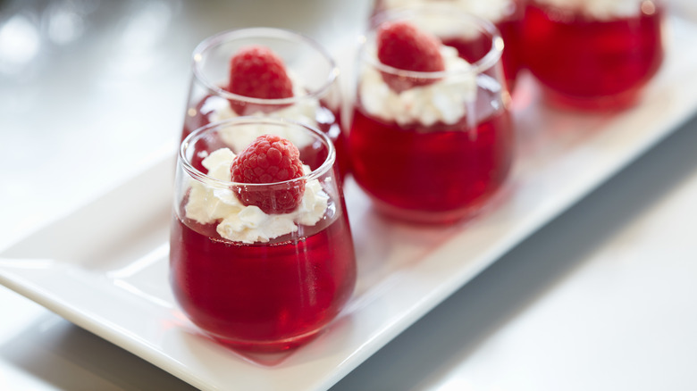 A red Jell-O shot is topped with a cream layer.