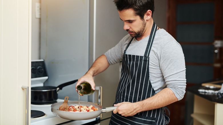 Man cooking with white wine