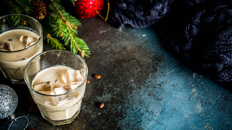 Two glasses of Irish creme over ice on a table with holiday decorations