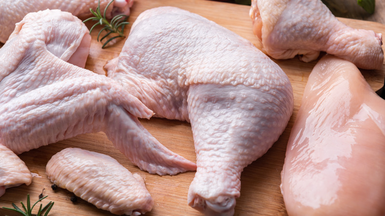 Raw chicken parts on a wood cutting board