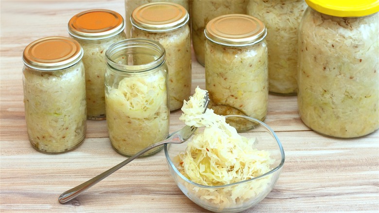 Several sauerkraut jars and a bowl of sauerkraut