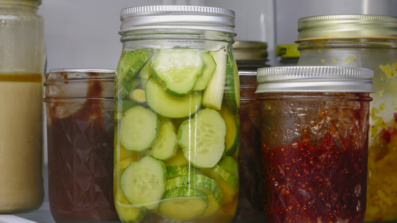 A jar of pickles, and other condiments, in the fridge.