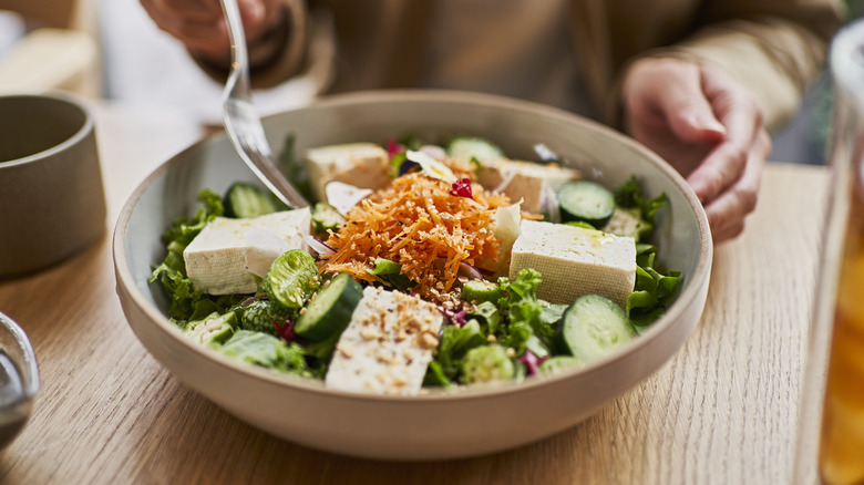 Person eating tofu salad bowl