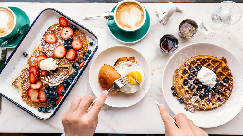 A person eating a large breakfast