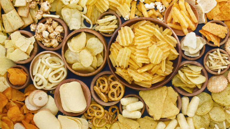 A variety of chips and snacks in small wooden bowls