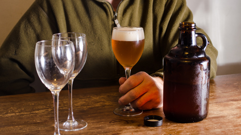 Person holding beer near growler