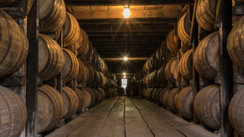 Rows of bourbon barrels aging in a rickhouse