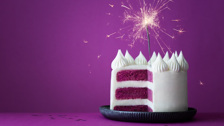 Small three-layer cake with a purple background