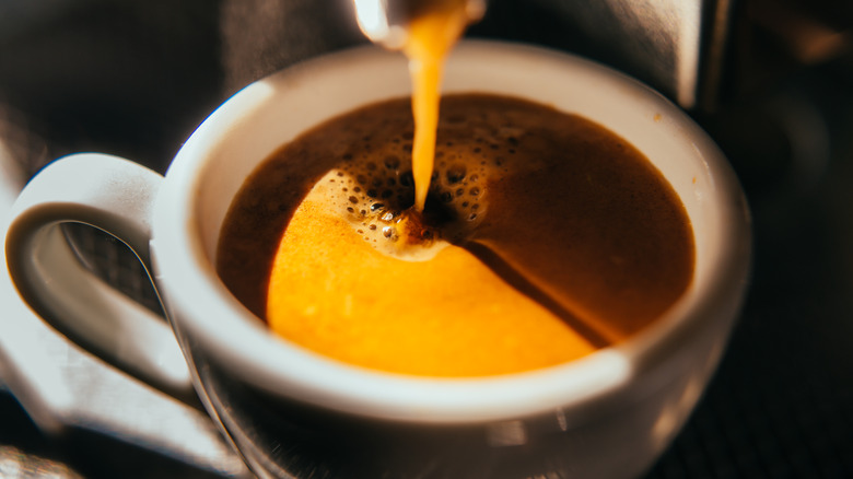 Brewing espresso into a porcelain cup