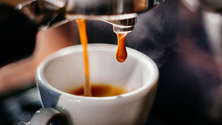 Espresso brewing into a cup