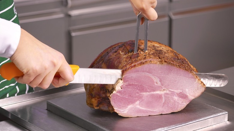 Cutting ham in kitchen