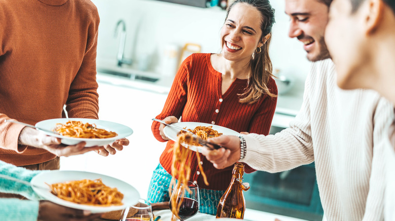 Friends eating plates of spaghetti