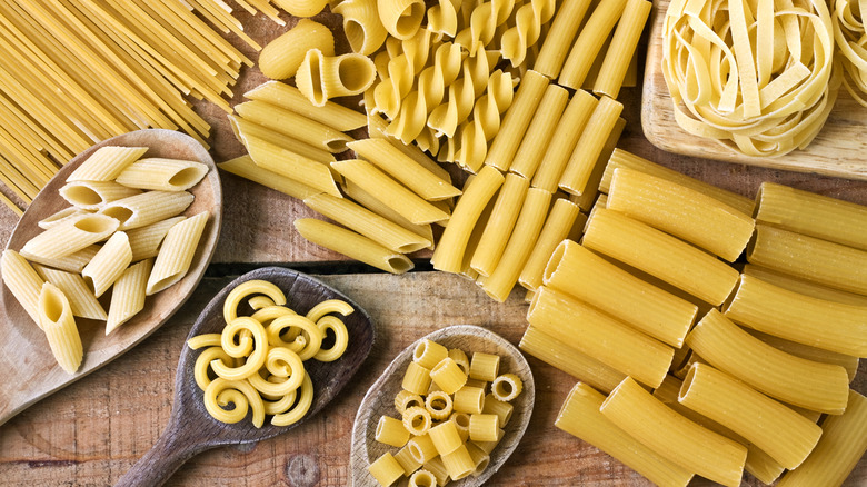 Different dried pastas on a wood surface