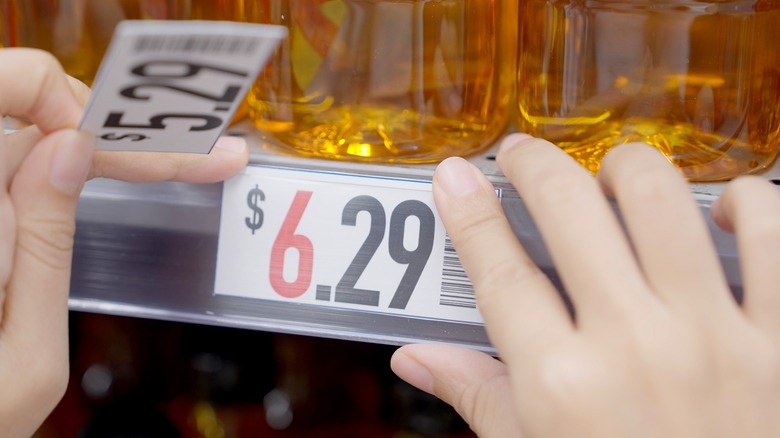 Hands replacing price tag on store shelf