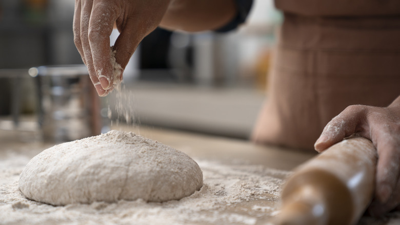 person kneading bread dough