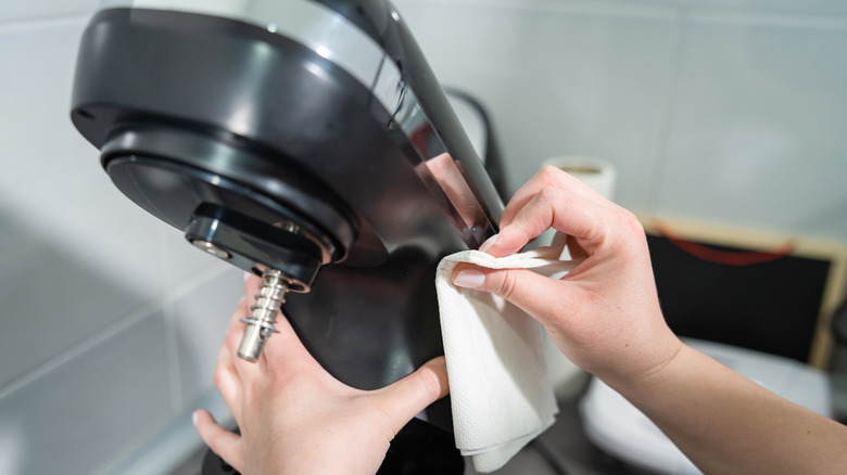 Hands cleaning a mixer stand