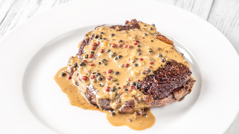 Steak with peppercorn sauce on a plate