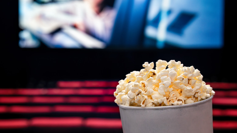 A bucket of popcorn in front of a cinema screen.