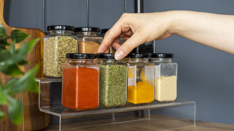 cropped hand reaching towards seasonings