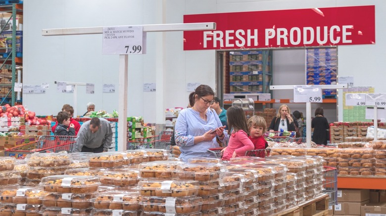 Costco members shopping for baked goods and produce.