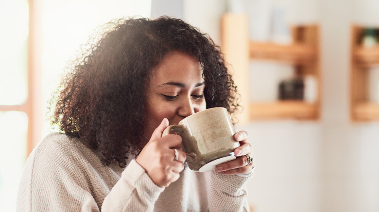 person sipping cup of coffee