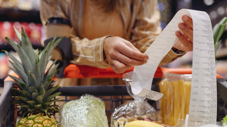 Woman scrutinizing grocery store receipt