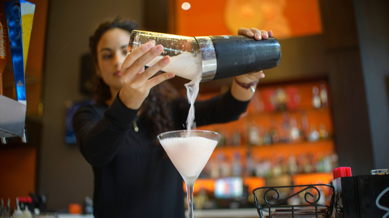 Mixologist pouring drink