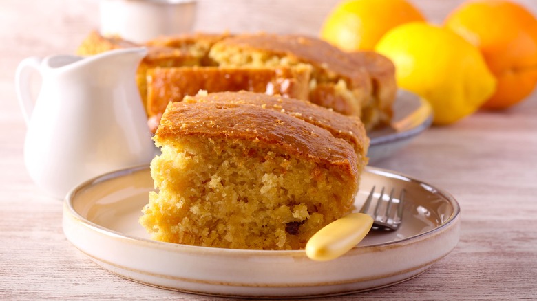 Lemon poke cake on a plate with fork