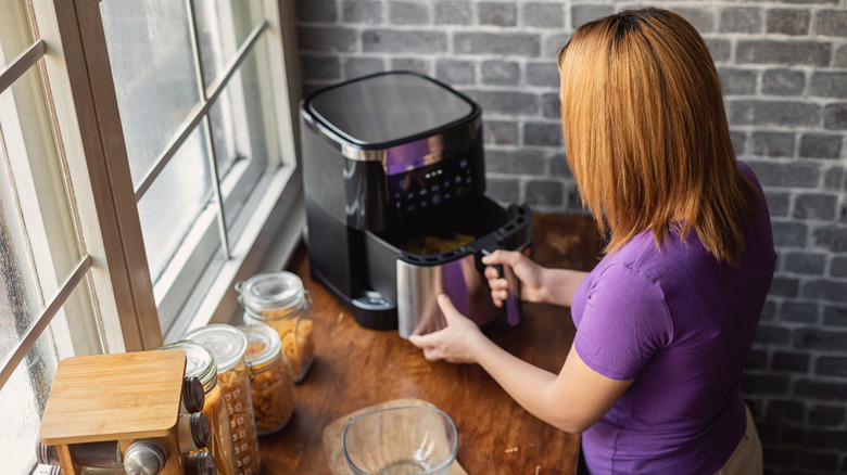 Person opening air fryer basket