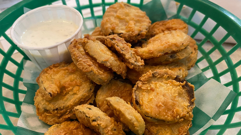 Fried pickle chips and ranch in green basket