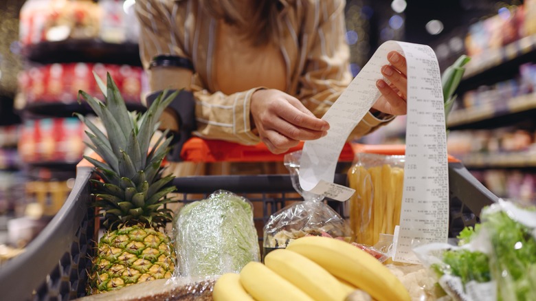 Shopper examining a receipt while grocery shopping