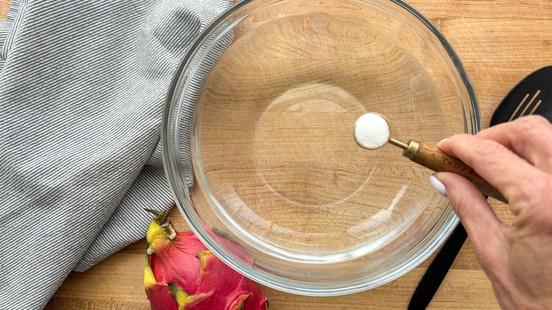 hand adding salt to bowl