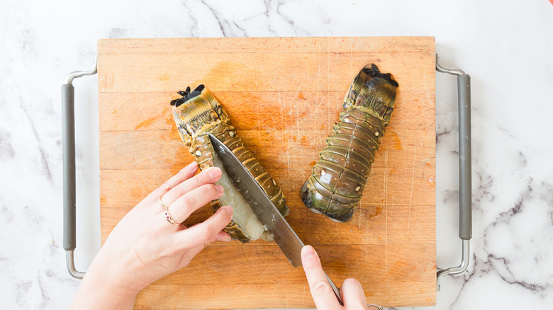 Knife cutting through lobster tail