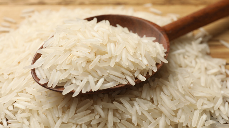 Wooden spoon filled with uncooked basmati rice