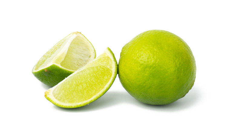 Lime and lime slices on white background