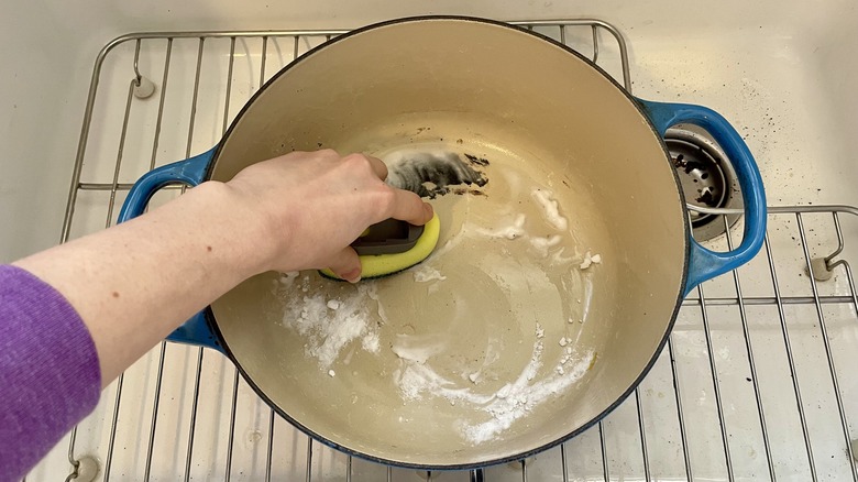 sponge cleaning a pan