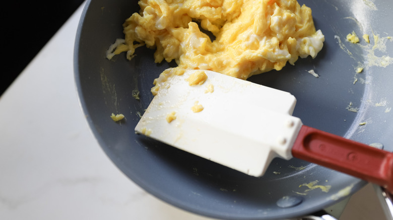 Rubber spatula stirring scrambled eggs