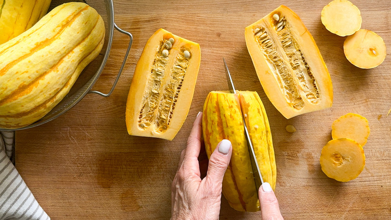 hands slicing the squash lengthwise