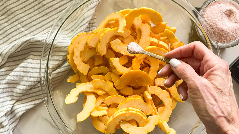 hand adding salt to bowl