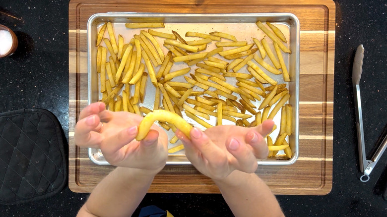 Hands breaking fry in half