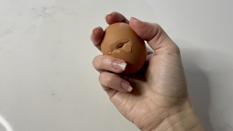 Cracked egg in hand