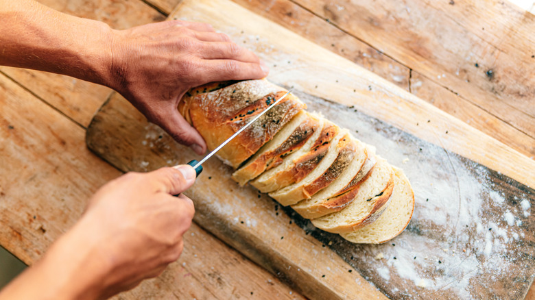 Person slicing bread on board