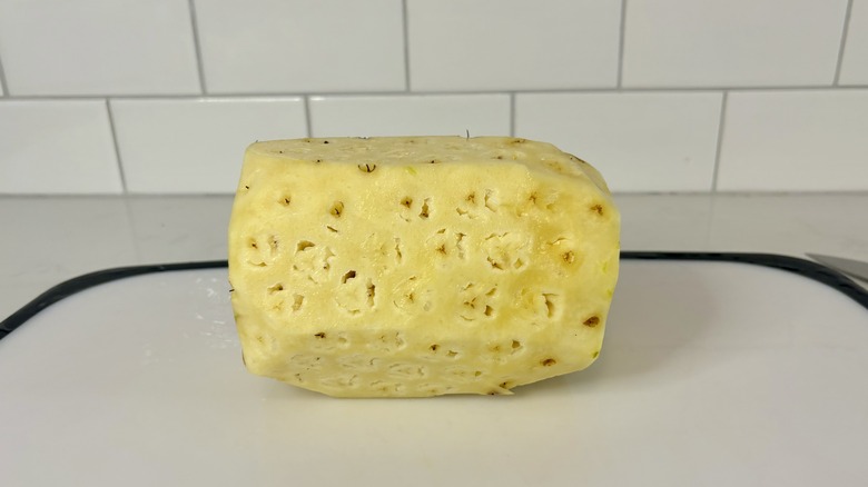 Peeled pineapple on cutting board