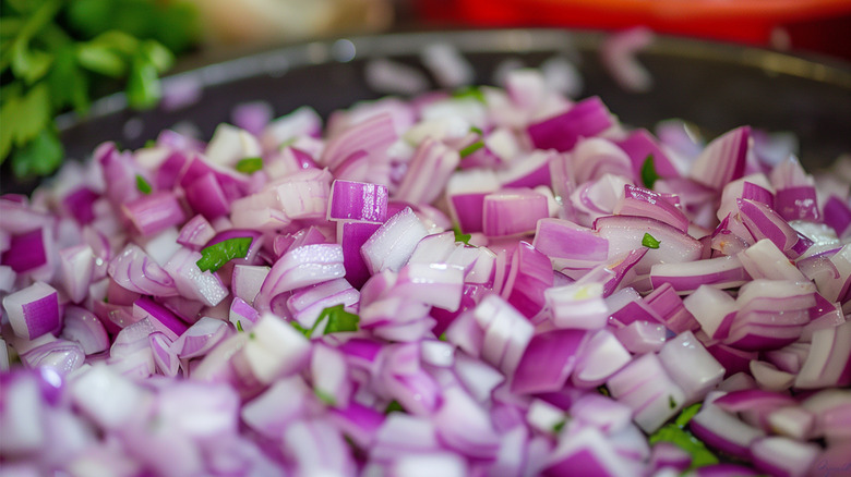 diced red onion in bowl with cilantro