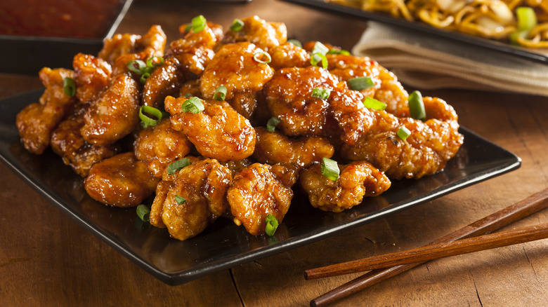 plate of orange chicken with chopsticks