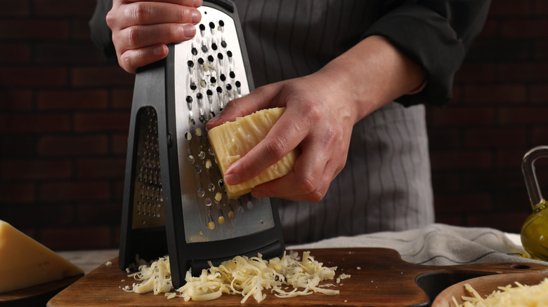 Person grating cheese on a box grater