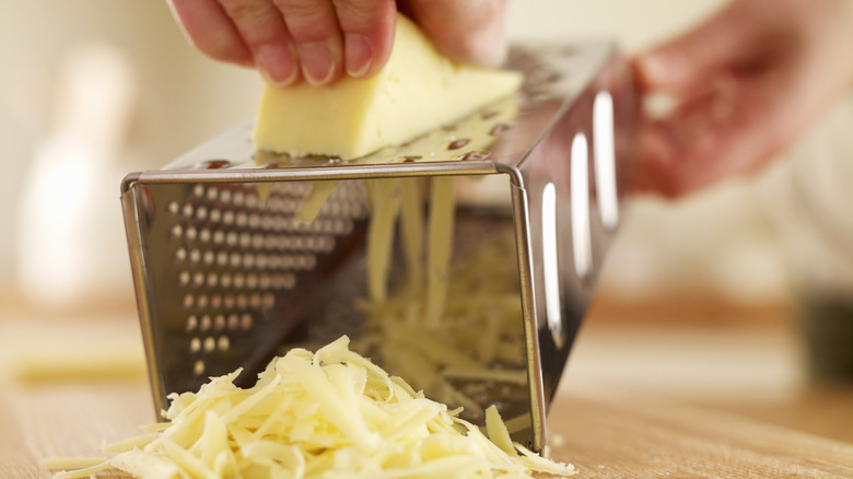 person using a cheese grater on its side