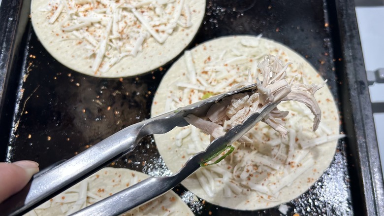 tongs with shredded chicken tacos