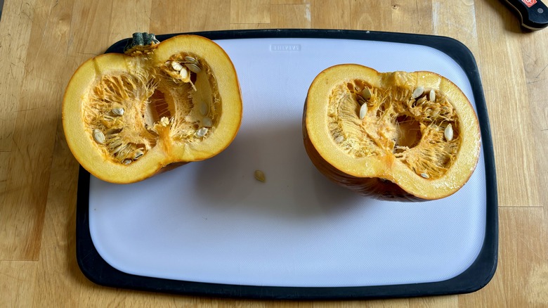 Halved pumpkin on cutting board